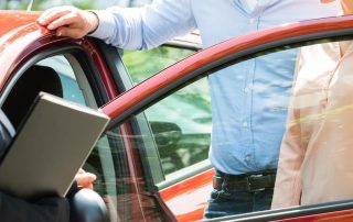 Sales associate showing car to couple