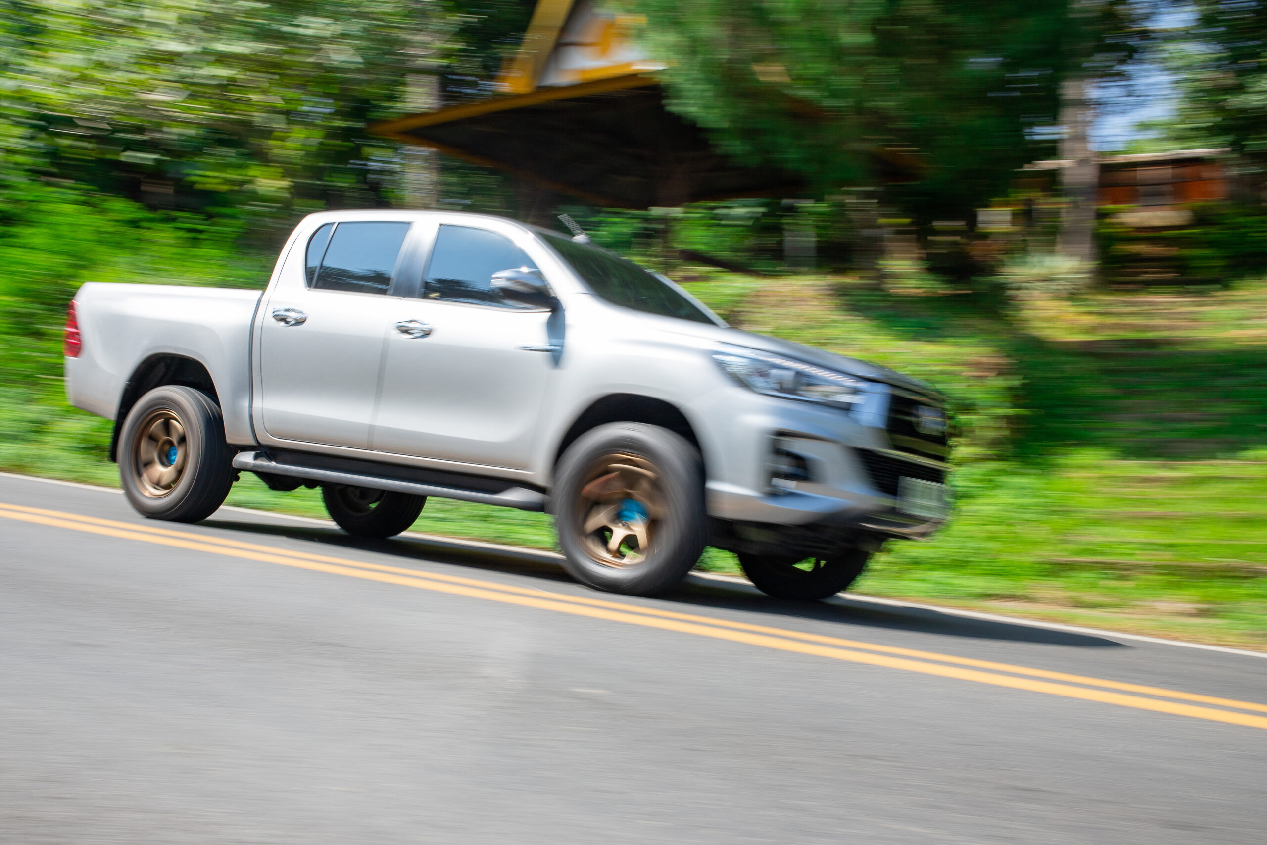 Blurry speedy movement of pickup truck driving on road Mechanic working on used vehicle - BENEFITS OF A USED TOYOTA concept image