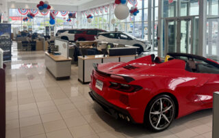 Dealership show room with red and white cars